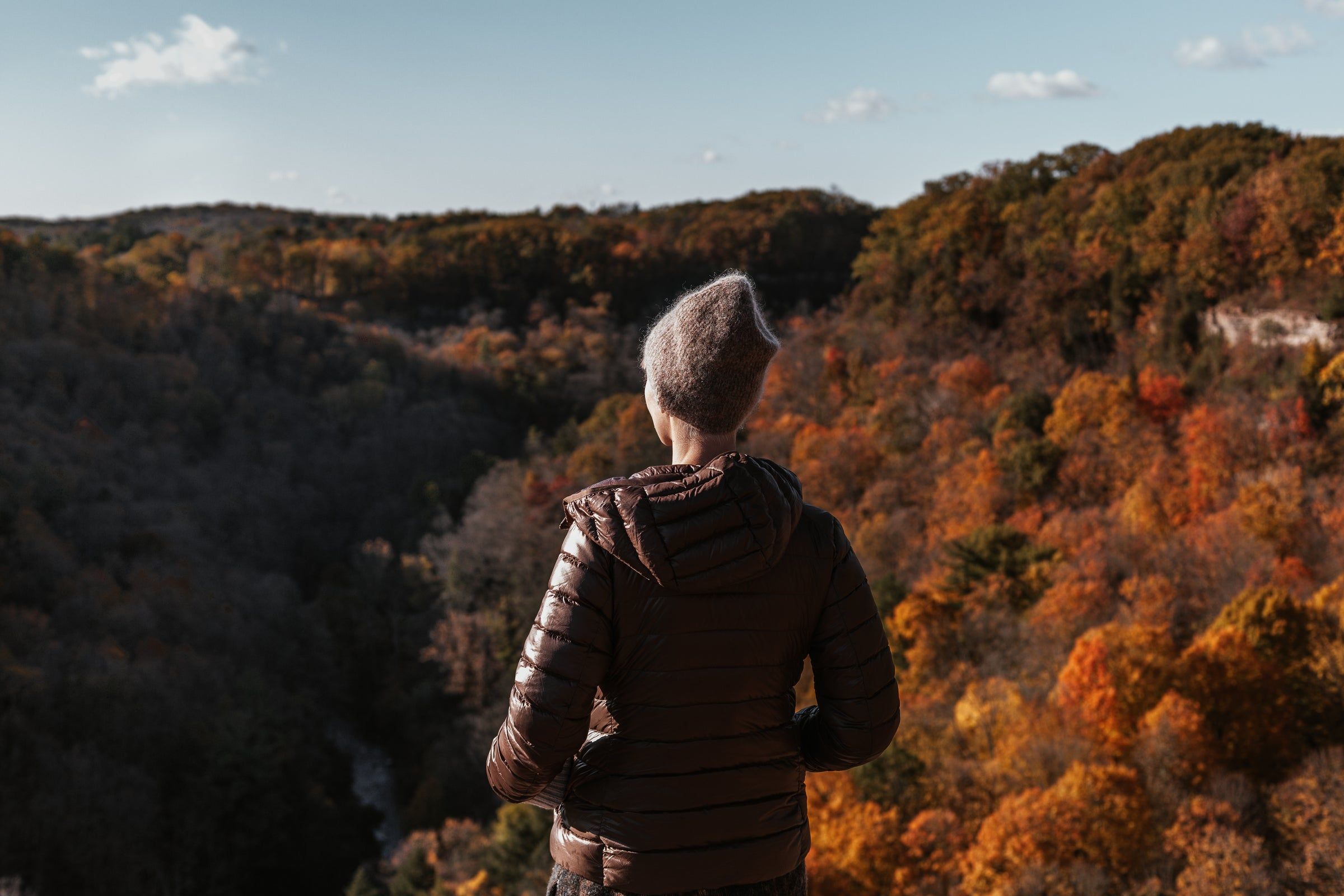Frau mit Blick über eine herbstliche Landschaft